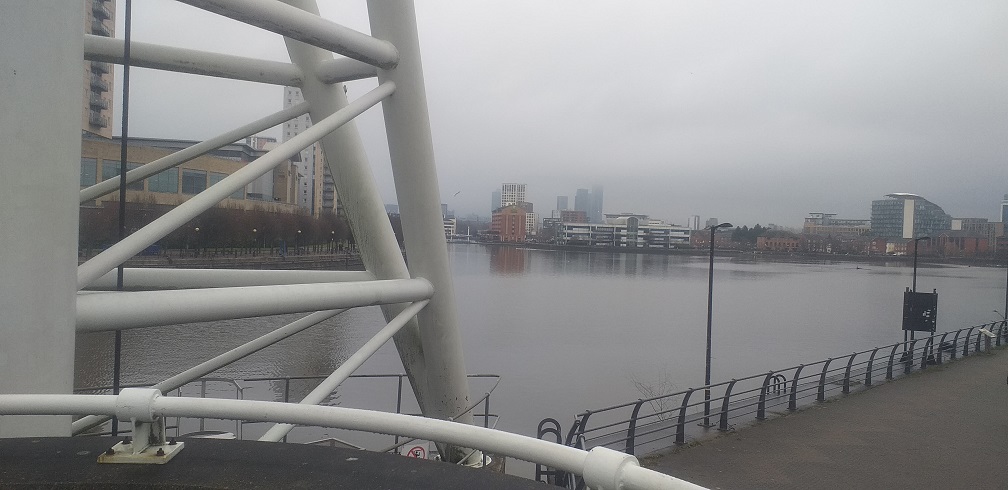 Manchester skyscrapers in the haze
        <br> from Salford Quays